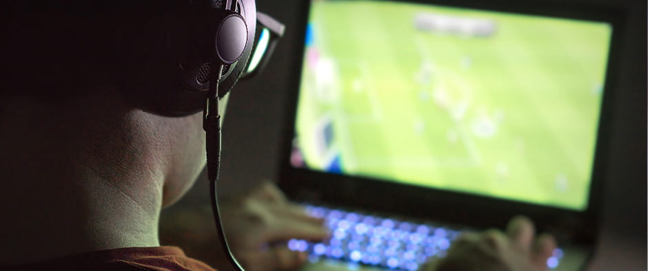 A gamer watching football on their computer