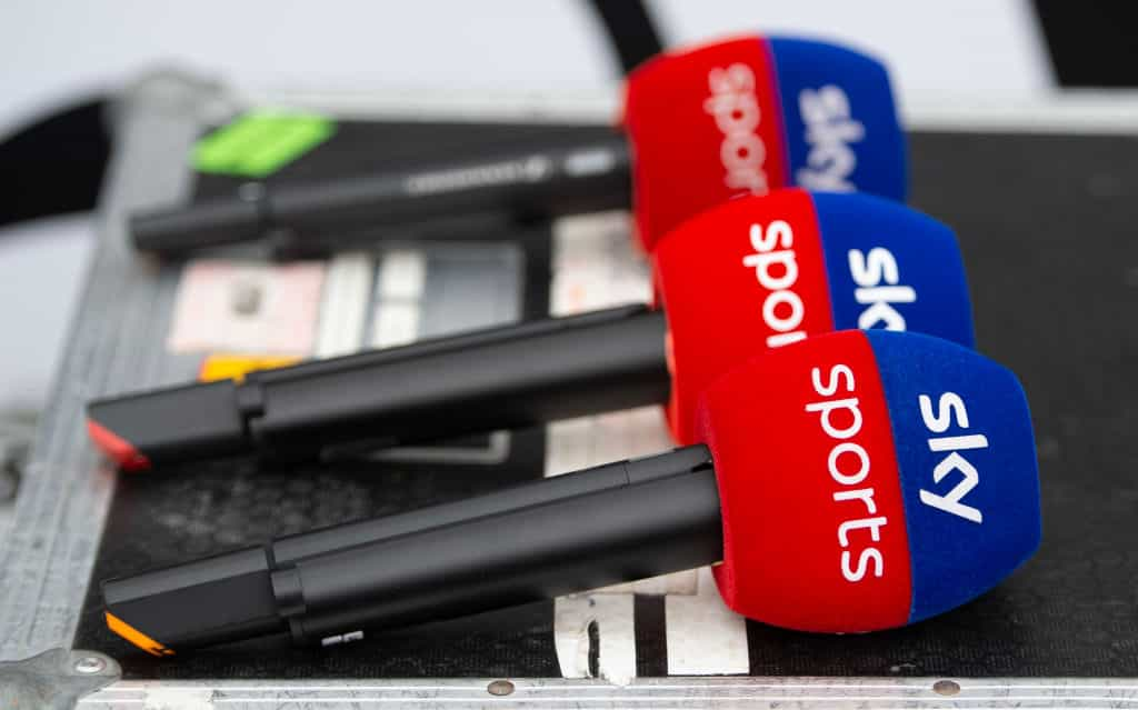 A row of three Sky Sports branded microphones.