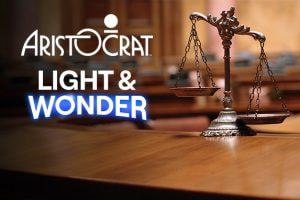 The uploaded image features a balanced scale, symbolizing justice, positioned on a wooden table, typically found in a courtroom setting. The background is blurred, giving focus to the scale. To the left of the scale, the logos of two companies are prominently displayed: "Aristocrat" in a sleek, modern font with a distinctive "O" featuring a dot above it, and "Light & Wonder" in a bold, blue font. The juxtaposition of these logos with the scale of justice visually represents the legal battle between the two companies.