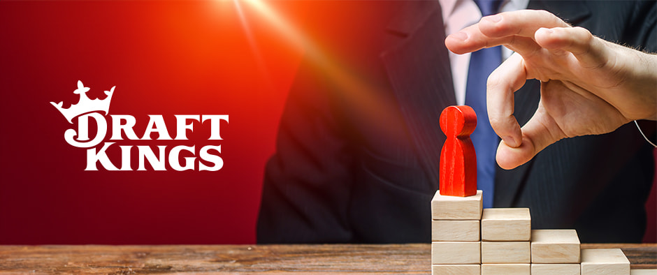 A businessman in a suit flicks a red pawn figure off a stack of wooden blocks, symbolizing a fall from power, with the DraftKings logo prominently displayed in the background.