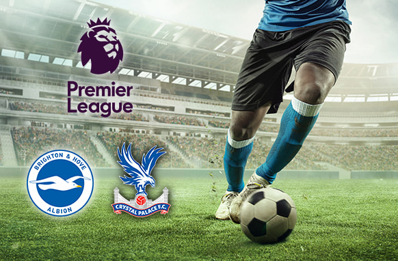 A football player in blue kit dribbles a ball on a pitch in a stadium. The Premier League logo and the Brighton & Hove Albion and Crystal Palace club logos are displayed.