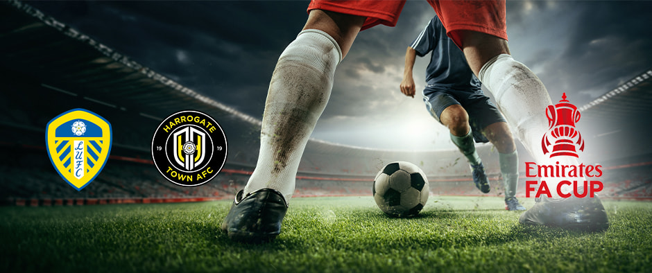 Two football players are on a pitch, and one is about to kick the ball, under dramatic skies and bright stadium lights. The image features the Leeds United and Harrogate Town AFC crests alongside the Emirates FA Cup logo, highlighting their upcoming match in the competition.