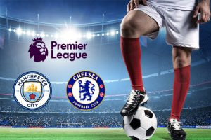 A football player in red socks stands on a vibrant green pitch with a ball, under bright stadium lights. The image prominently features the Manchester City and Chelsea crests alongside the Premier League logo, highlighting their upcoming match in the tournament.