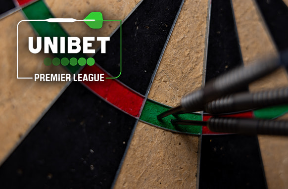 Close-up image of a dartboard showing three darts tightly grouped in the green triple section. The Unibet Premier League logo is prominently displayed in the upper left corner, featuring a green dart graphic and the company's name. The background highlights the texture of the dartboard segments, emphasizing the precision of the dart throws.