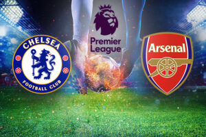 A dramatic football image featuring a player about to kick a ball on a vivid green pitch. The logos of Chelsea Football Club and Arsenal Football Club are prominently displayed on either side, with the Premier League logo above, set against a brightly lit stadium backdrop.